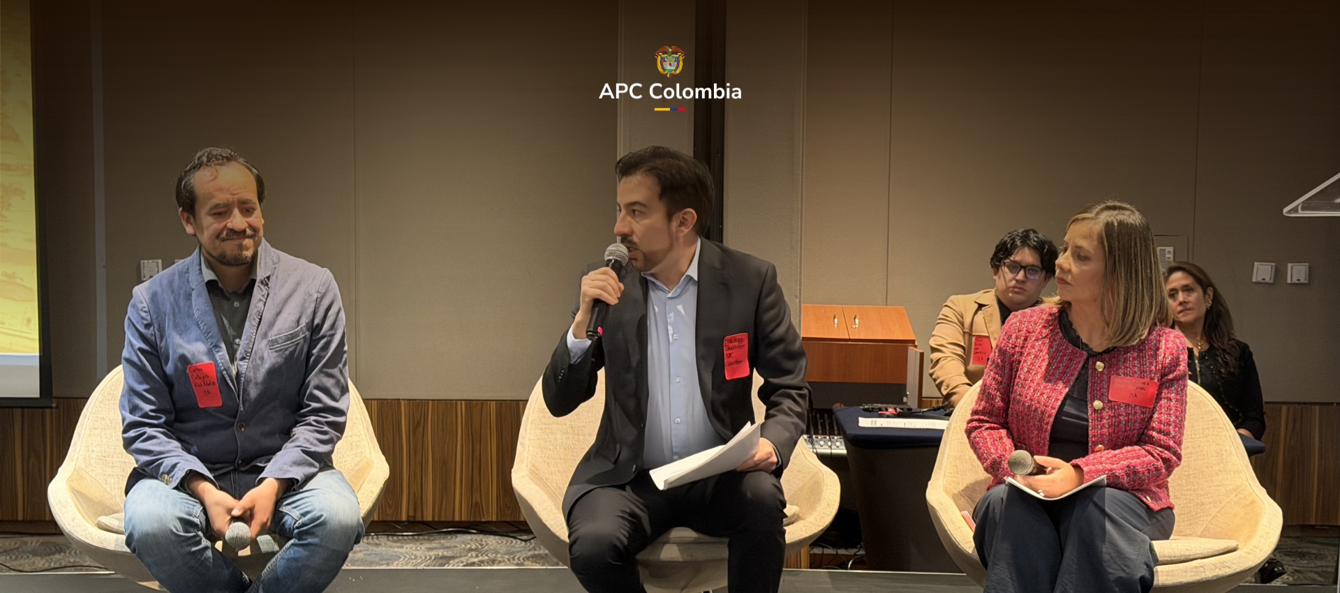 Una foto en la que esta Santiago Quiñones, director de Demanda de Cooperación Internacional de APC Colombia con una representante de ONU Mujeres y un representante de RED ADELCO, en el evento del GPEDC