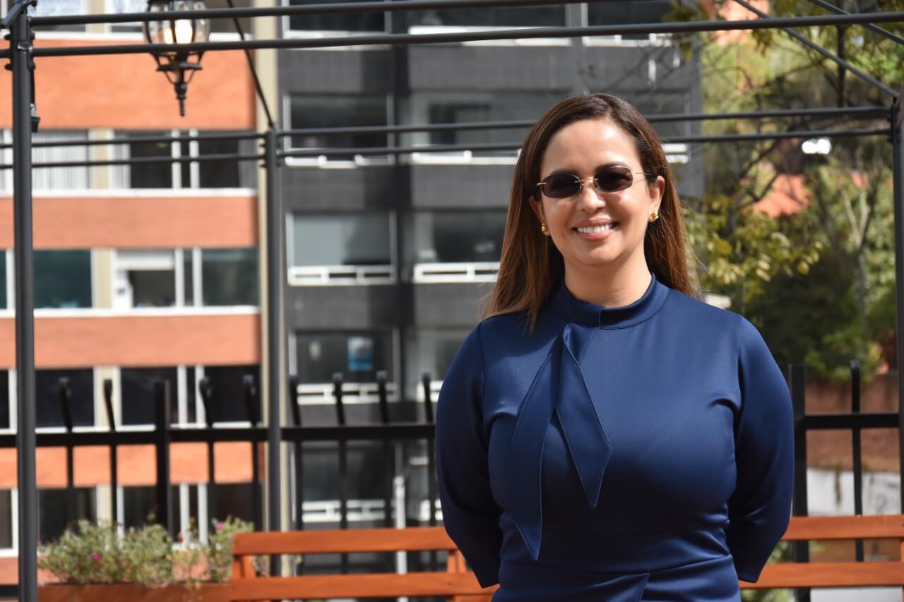 Foto de la directora Viviana Manrique al aire libre con una blusa de color negro.