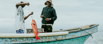 Fotografía de dos Afrocolombianos sacando un pez en el pacífico colombiano