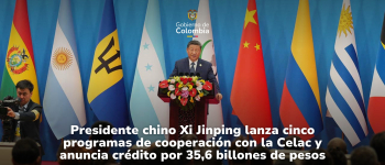 El presidente chino, Xi Jinping, dando un discurso, en la parte de atrás varias banderas, entre ellas se ve la de Colombia