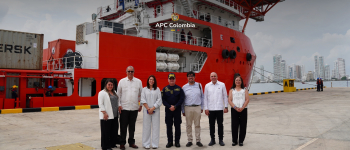 La directora general de APC Colombia, Alexandra Palencia con el embajador de Cuba en Colombia y representantes de los dos países al lado del buque que salió con la asistencia humanitaria