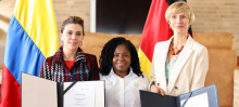 A la izquierda la directora general de APC-Colombia, en el medio la Vicepresidenta de Colombia, Francia Márquez, a la derecha Rebekka Rust, Líder del área temática de paz y cohesión social de la GIZ, atrás de ellas la bandera de Colombia y Alemania